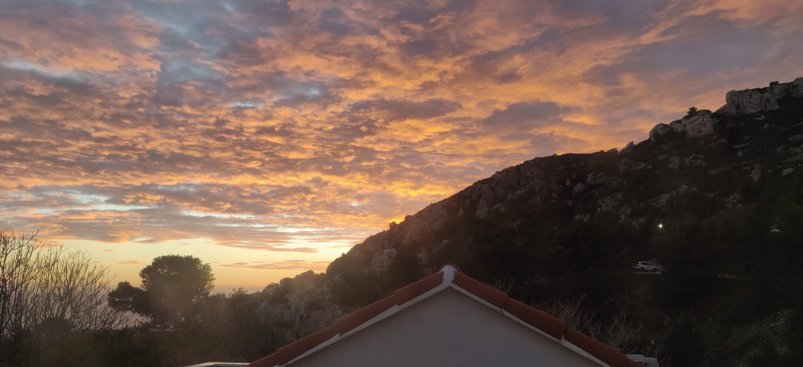 Coucher de soleil rose sur la colline, vu du toit-terrasse de la Cabane