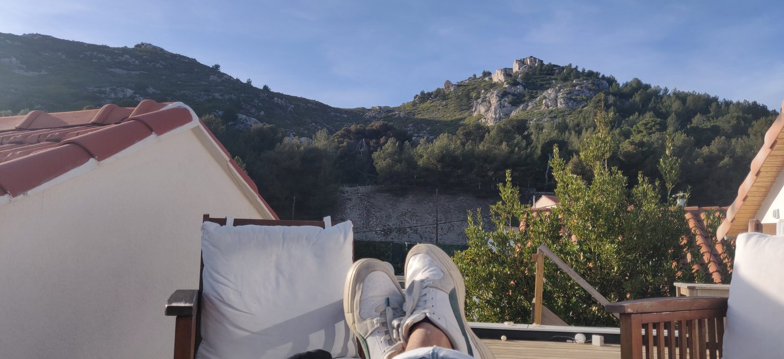 Les pieds sur le canapé du toit-terrasse, face aux collines de Niolon