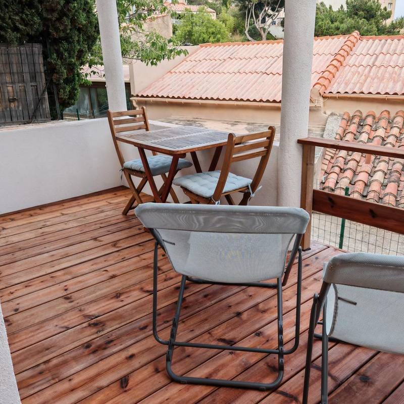 La table et les chaises sur la terrasse en bois de la cabine