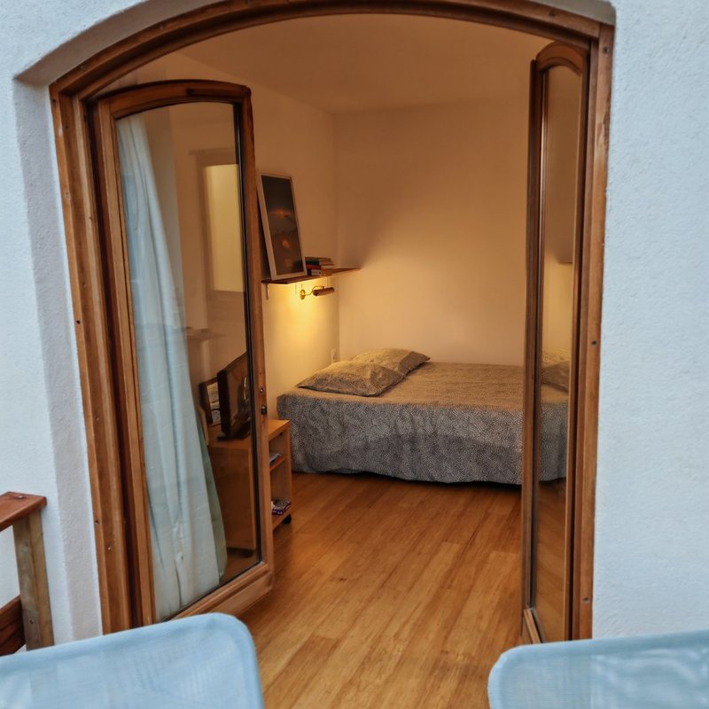 Le lit vu depuis la terrasse, à travers la porte cintrée