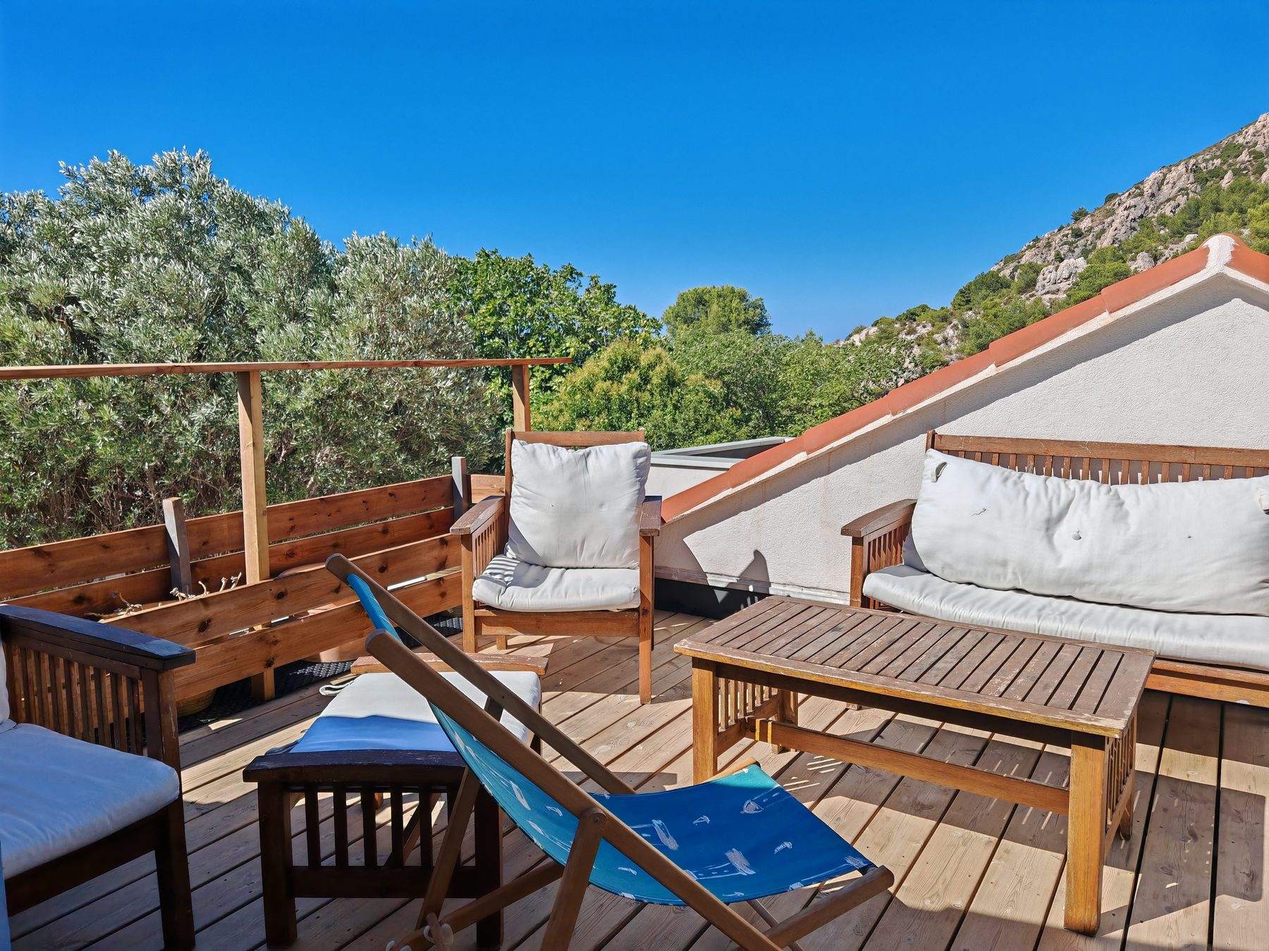 Le toit-terrasse en bois de la Cabane de Niolon, face aux collines de la calanque