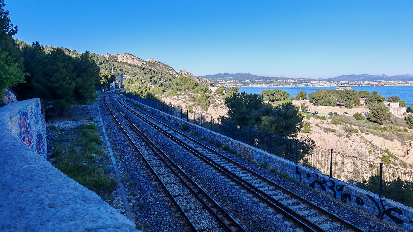 La voie de la Côte Bleue en courbe vers Niolon, la baie de Marseille au fond