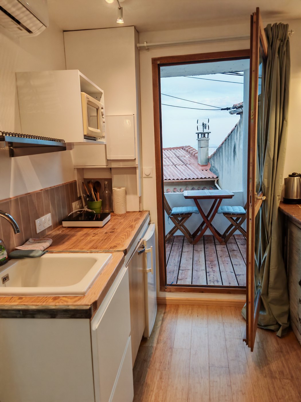 Le coin cuisine et la porte ouverte sur la terrasse