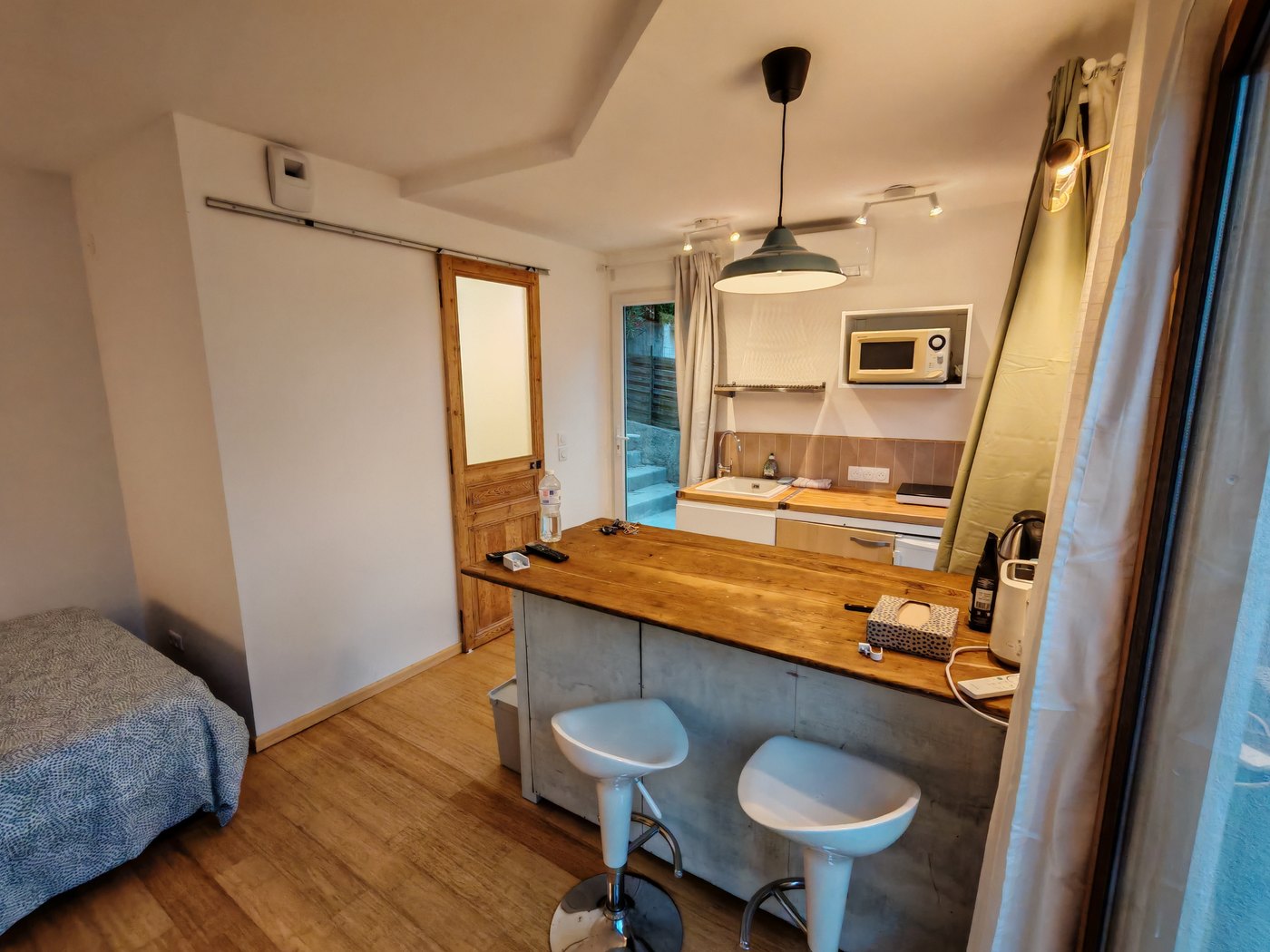 Le séjour du studio, le coin cuisine et la porte de la terrasse